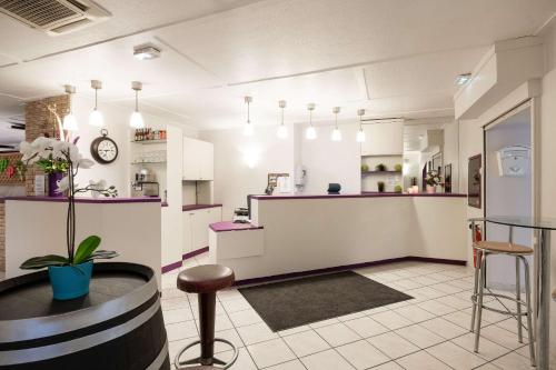 a kitchen with white cabinets and purple counter tops at Comfort Hotel Grenoble Meylan in Meylan