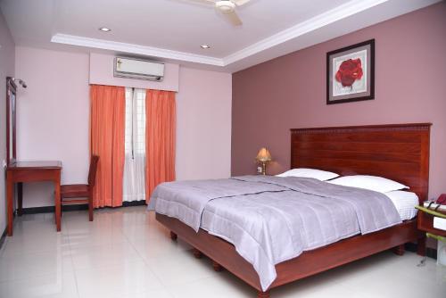 a bedroom with a large bed and a desk at Hotel Subhalakshmi Palace in Kāraikkudi
