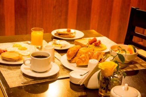 a table with plates of food and a cup of coffee at Gringo Bill's Boutique Hotel in Machu Picchu