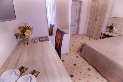 a bedroom with a table with a vase of flowers on it at Hotel Grand Yelets in Yelets