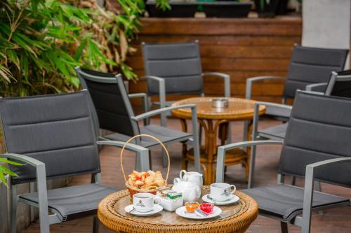 a table with a bowl of food and cups and chairs at Kandy City Hotel by Earl's in Kandy