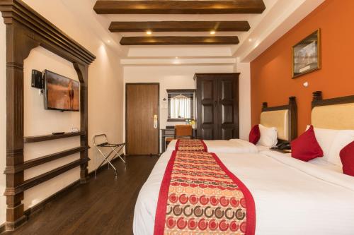 a hotel room with two beds and a tv at Hotel Moonlight in Kathmandu