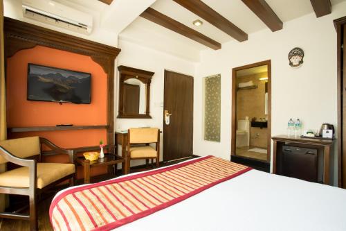 a bedroom with a bed and a desk and a television at Hotel Moonlight in Kathmandu
