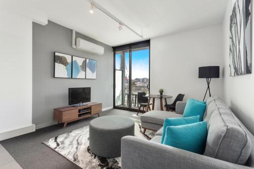 uma sala de estar com um sofá e uma televisão em Docklands Private Collection - Digital Harbour em Melbourne