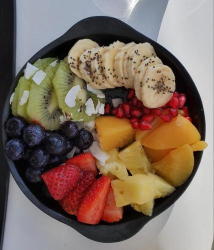 a black bowl filled with fruit and vegetables at Waters Edge B&B in Whitianga