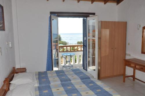 una camera con letto e un balcone con vista sull'oceano di Villa Maria a Marathokampos