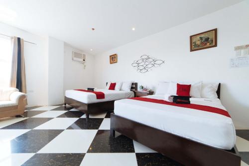 two beds in a room with a checkered floor at RedDoorz Plus @ San Roque Roxas City in Roxas City