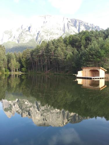 a reflection of a house in the water in front of a mountain at Gfliererhof in Fiè
