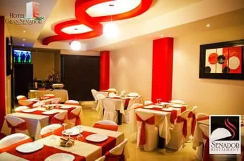 un restaurante con mesas y sillas en una habitación en Hotel Gran Senador, en Portoviejo