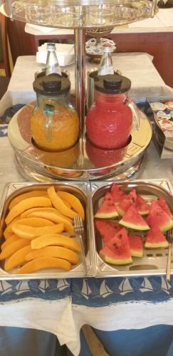 a table with plates of fruit and jars of sauce at Hotel Corallo in Francavilla al Mare