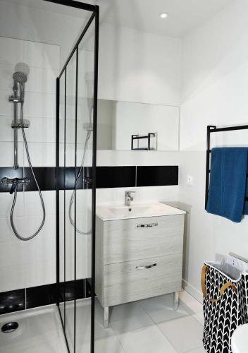 une salle de bain blanche avec une douche et un lavabo dans l'établissement CLOS DES THERMES A JONZAC, à Jonzac