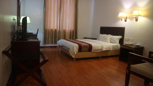 a bedroom with a bed and a television in it at Beach Garden Hotel in Dili