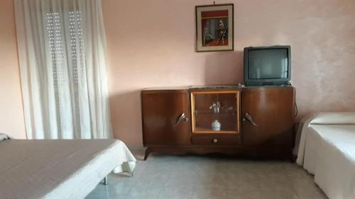 a living room with a tv and a cabinet with a tvictericter at Casa Vacanze nel Verde a 5 Km dal mare in Nettuno