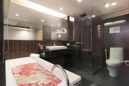 Furama Silom Hotel في بانكوك: حمام مع حوض ومغسلة ومرحاض