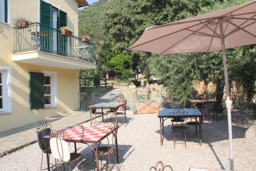 a group of tables and chairs with an umbrella at Ai Cinque Campanili in Finale Ligure