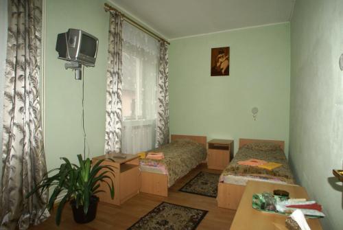 a small room with two beds and a tv at Europa in Rakhiv