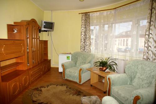 a living room with two chairs and a television at Europa in Rakhiv