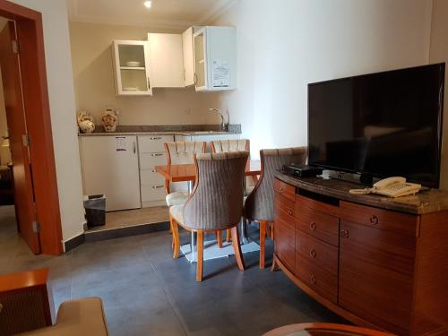 a living room with a television and a kitchen at ماجيك سويت ابوحليفة Magic Suite Abu Halifa in Kuwait