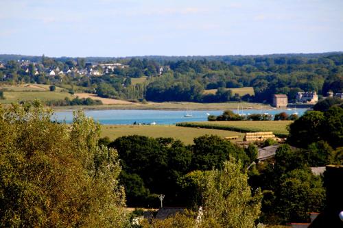 a view of a river with trees and a town at La Maison de Mano in Plouër-sur-Rance
