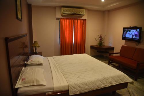 a bedroom with a large bed and a television at Hotel Subhalakshmi Palace in Kāraikkudi