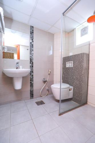 a bathroom with a shower and a toilet and a sink at ماجيك سويت ابوحليفة Magic Suite Abu Halifa in Kuwait