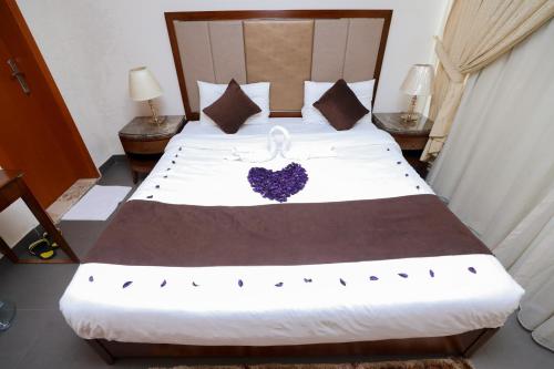 a bedroom with a large bed with a heart pillow at ماجيك سويت ابوحليفة Magic Suite Abu Halifa in Kuwait