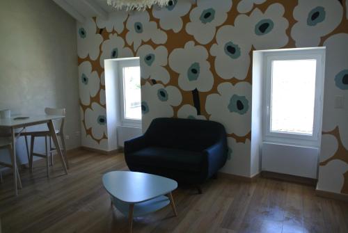a living room with a chair and a table at Le Duplex de Saint Rémy de Provence in Saint-Rémy-de-Provence