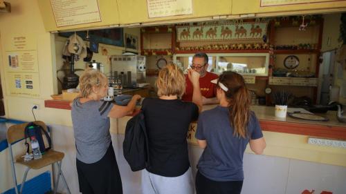 a group of three women standing at a counter at Negev Camel Ranch in Dimona