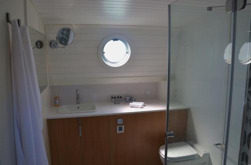 a bathroom with a sink and a toilet and a window at Tagus Marina in Lisbon