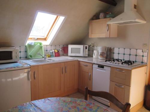 une petite cuisine avec un évier et un micro-ondes dans l'établissement 3 Rue Vicaire, à Contalmaison