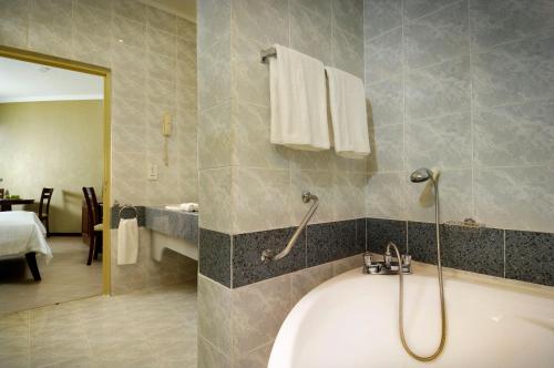 een badkamer met een bad en een wastafel bij Berjaya Beau Vallon Bay Resort & Casino in Beau Vallon