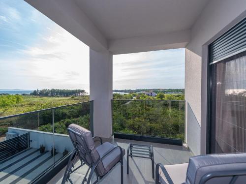 a balcony with two chairs and a view at Villa Contessa in Privlaka