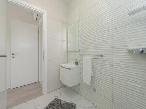 a white bathroom with a toilet and a shower at Villa Contessa in Privlaka