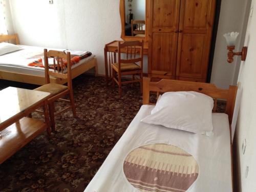 a room with two beds and a table and chairs at Katerina Family Hotel in Smolyan