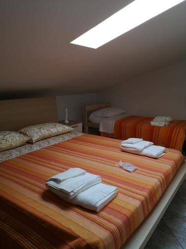 sypialnia z 2 łóżkami i ręcznikami w obiekcie Sul Confine w mieście Cervia
