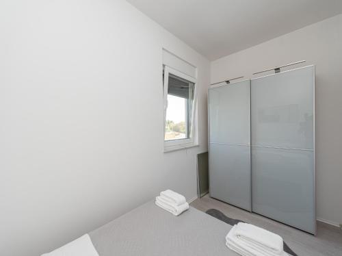 a white bathroom with a glass shower with two towels at Villa Contessa in Privlaka