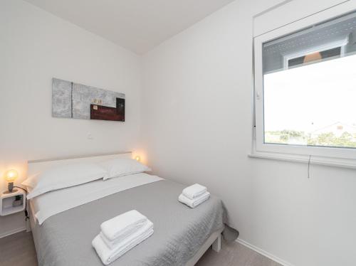 a white bedroom with a bed and a window at Villa Contessa in Privlaka