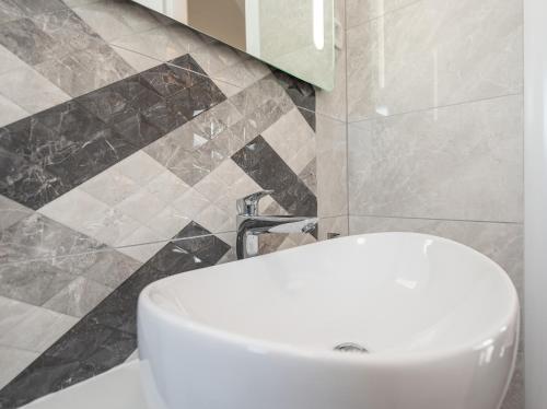 a bathroom with a white toilet and a sink at Villa Contessa in Privlaka