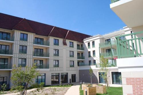 
a large building with a view of a city at Résidence Services Seniors Domitys - Les Safrans in Dives-sur-Mer
