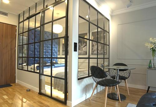 une pièce avec une table, des chaises et une fenêtre dans l'établissement Blue Velvet Premium Apartments, à Toruń