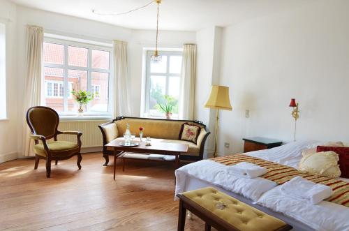 een slaapkamer met een bed, een bank en een tafel bij Struckshus in Tønder