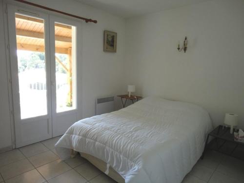 une chambre blanche avec un lit et une fenêtre dans l'établissement Grande Terrasse 800m Plage Demoiselles, à Saint-Jean-de-Monts