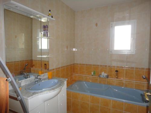 une salle de bain avec une baignoire, un lavabo et un miroir dans l'établissement Grande Terrasse 800m Plage Demoiselles, à Saint-Jean-de-Monts