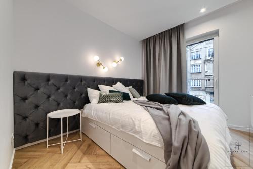 a bedroom with a large bed with a black headboard at Apartament DeLux in Poznań