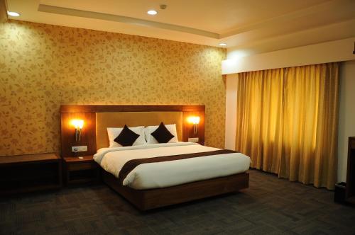 1 dormitorio con 1 cama grande y 2 lámparas en Hotel Ambient Turret, en Bangalore