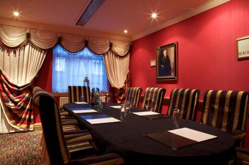 a restaurant with a table and chairs in a red room at Manchester South Hotel, Sure Hotel Collection by BW in Manchester