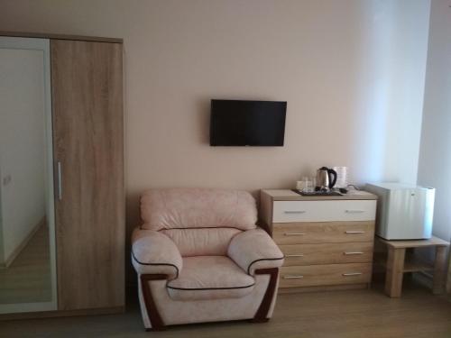 a room with a chair and a television on a wall at Hotel Elita in Odesa