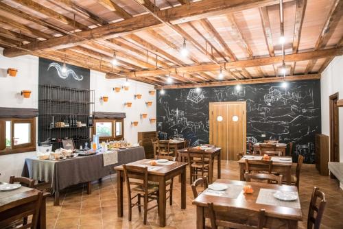 a restaurant with wooden tables and a chalkboard wall at Agriturismo La Valle Di Vico in Caprarola