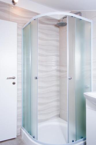 a shower with a glass door in a bathroom at Apartments Dolores in Šibenik