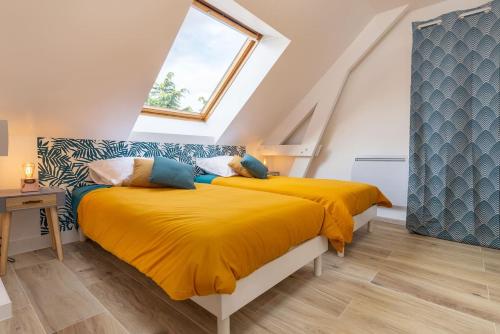 2 łóżka w sypialni na poddaszu z żółtą pościelą w obiekcie Superbe Appartement 4 pers + 1bb - 3km DisneyLand w mieście Magny-le-Hongre